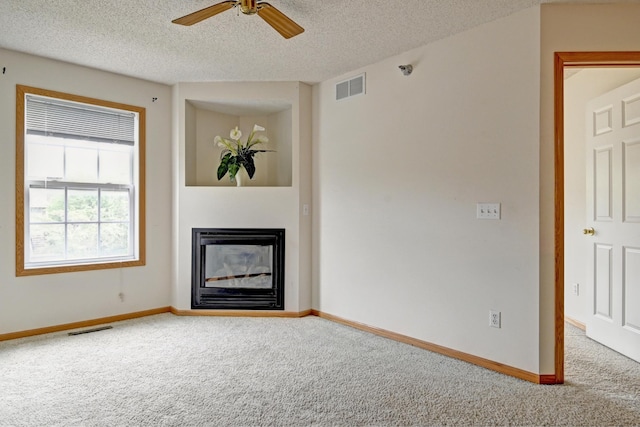 11307 Chisholm Cir NE Unit C, Blaine, MN 55449 - unfurnished living room with carpet flooring, ceiling fan, a textured ceiling, and a glass covered fireplace
