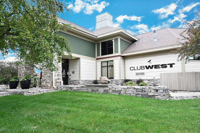 11307 Chisholm Cir NE Unit C, Blaine, MN 55449 - rear view of property featuring stone siding, roof with shingles, a chimney, and an attached garage