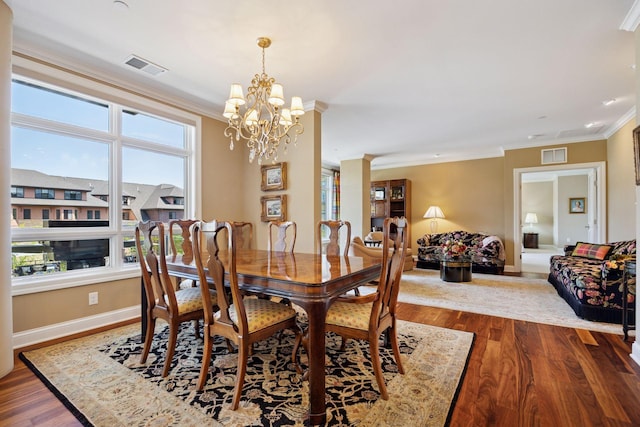 875 Lake St N Unit 318, Wayzata, MN 55391 - dining area featuring a chandelier, crown molding, and dark wood-style floors