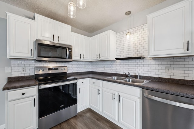 12651 8th Ave S, Zimmerman, MN 55398 - kitchen featuring stainless steel appliances, dark countertops, dark wood finished floors, white cabinetry, and a textured ceiling