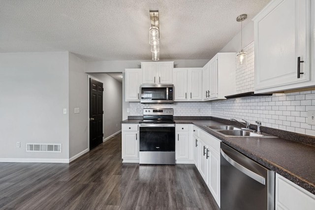 12651 8th Ave S, Zimmerman, MN 55398 - kitchen with appliances with stainless steel finishes, dark countertops, backsplash, a textured ceiling, and dark wood finished floors