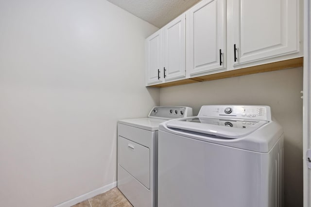 12651 8th Ave S, Zimmerman, MN 55398 - laundry area featuring washing machine and dryer, cabinet space, light tile patterned flooring, and a textured ceiling