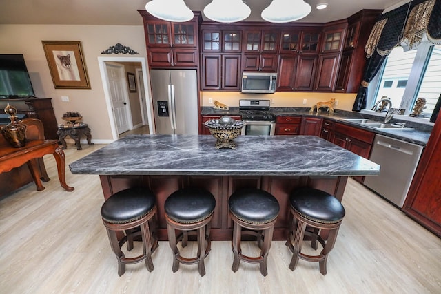 915 Darling Dr NW, Alexandria, MN 56308 - kitchen with appliances with stainless steel finishes, dark brown cabinets, light wood-type flooring, and dark countertops