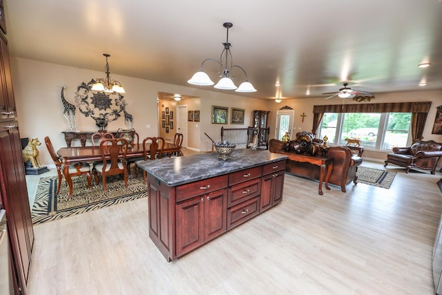 915 Darling Dr NW, Alexandria, MN 56308 - kitchen with open floor plan, light wood-style flooring, dark brown cabinets, dark countertops, and a chandelier