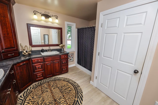 915 Darling Dr NW, Alexandria, MN 56308 - bathroom featuring vanity, wood finished floors, and a shower with curtain