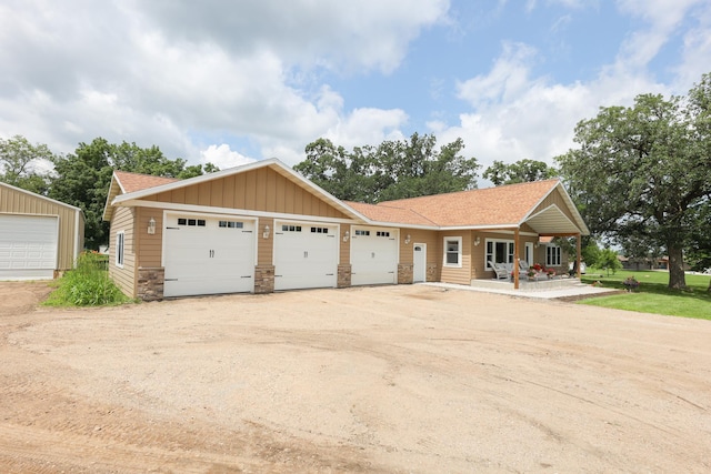 915 Darling Dr NW, Alexandria, MN 56308 - view of front of home featuring covered porch, stone siding, board and batten siding, and a garage