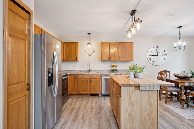 1807 Lachman Ave NE, Saint Michael, MN 55376 - kitchen with appliances with stainless steel finishes, light wood finished floors, a textured ceiling, hanging light fixtures, and butcher block countertops
