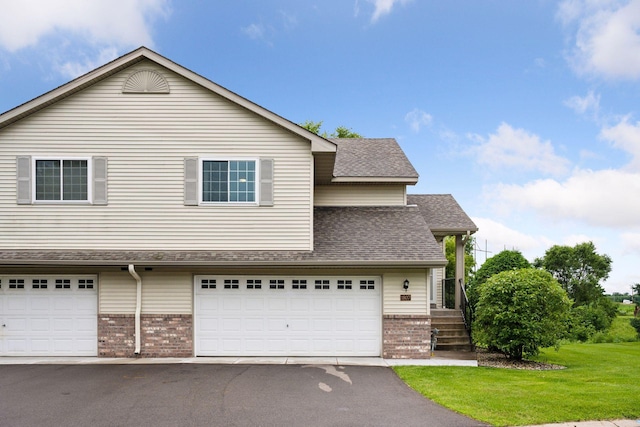 1807 Lachman Ave NE, Saint Michael, MN 55376 - traditional-style home with brick siding, a front yard, a garage, roof with shingles, and driveway