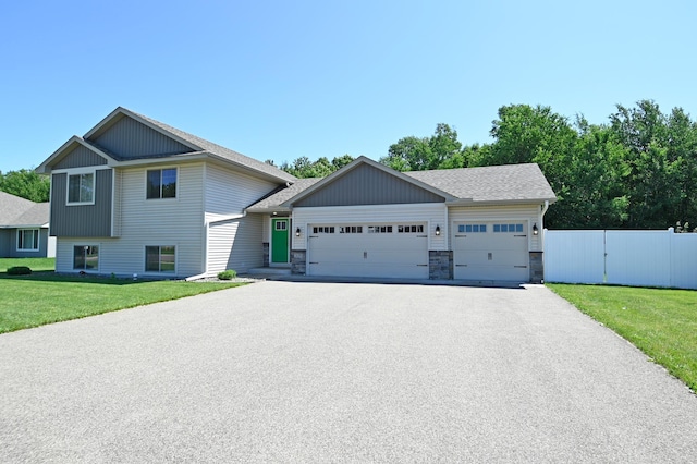 38391 Hunters Ridge Trl, North Branch, MN 55056 - split level home with asphalt driveway, an attached garage, roof with shingles, and stone siding