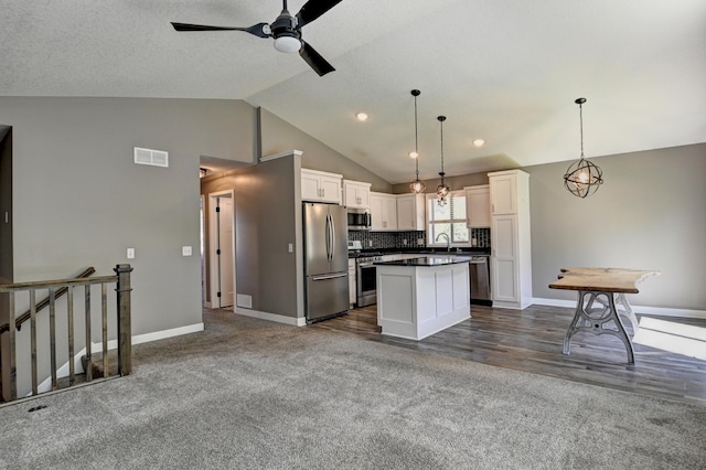 38391 Hunters Ridge Trl, North Branch, MN 55056 - kitchen featuring stainless steel appliances, a ceiling fan, a center island, white cabinetry, and dark countertops