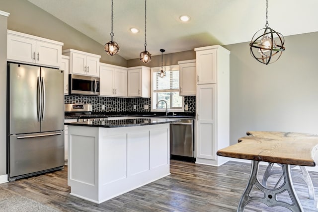 38391 Hunters Ridge Trl, North Branch, MN 55056 - kitchen with appliances with stainless steel finishes, vaulted ceiling, dark countertops, tasteful backsplash, and dark wood-style flooring