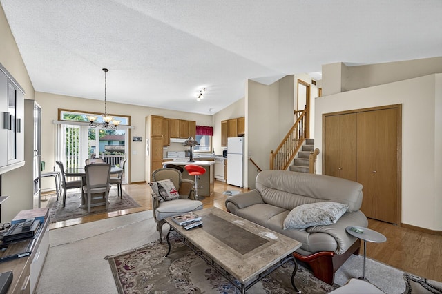 7217 92nd Trl N, Brooklyn Park, MN 55445 - living room with healthy amount of natural light, a chandelier, lofted ceiling, stairway, and light wood finished floors