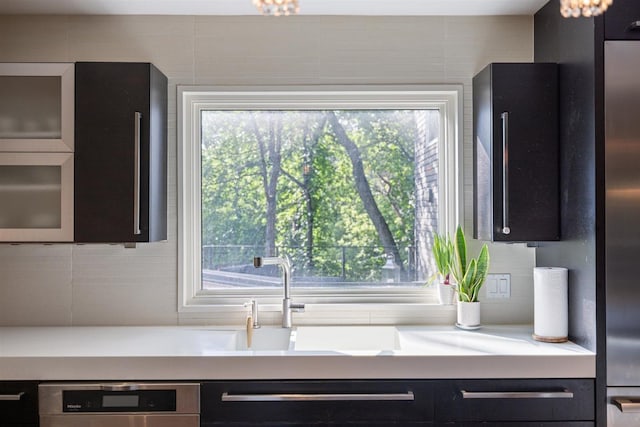 1921 Ewing Ave S, Minneapolis, MN 55416 - kitchen featuring backsplash, light countertops, dark cabinetry, and glass insert cabinets