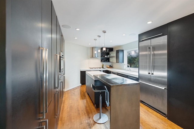 1921 Ewing Ave S, Minneapolis, MN 55416 - kitchen featuring high quality fridge, wall chimney exhaust hood, a kitchen island, pendant lighting, and light wood-style flooring