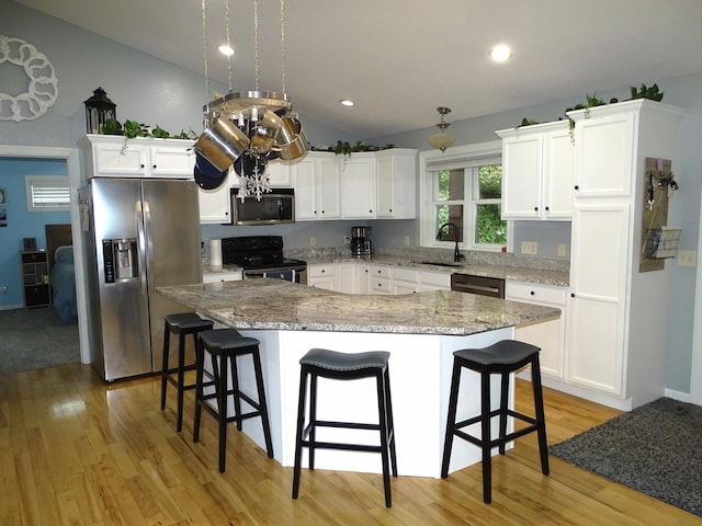 568 Midway Rd, Menomonie, WI 54751 - kitchen featuring stainless steel appliances, light wood-type flooring, vaulted ceiling, white cabinets, and a center island