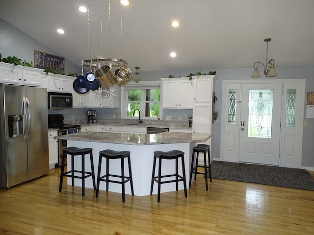 568 Midway Rd, Menomonie, WI 54751 - kitchen featuring appliances with stainless steel finishes, a breakfast bar, white cabinets, a kitchen island, and recessed lighting