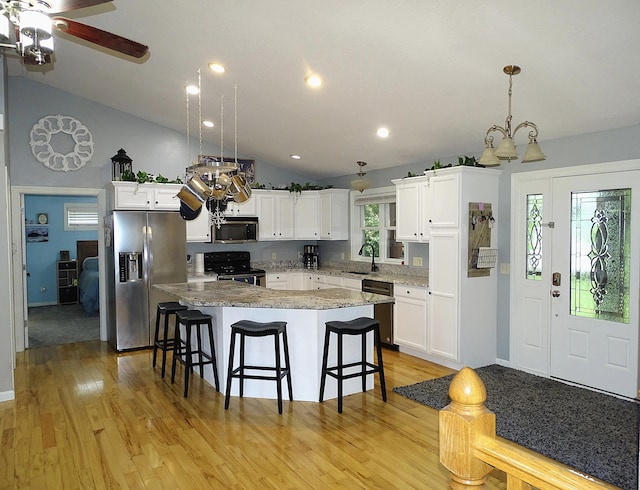 568 Midway Rd, Menomonie, WI 54751 - kitchen featuring stainless steel appliances, lofted ceiling, a kitchen island, a breakfast bar, and light wood finished floors