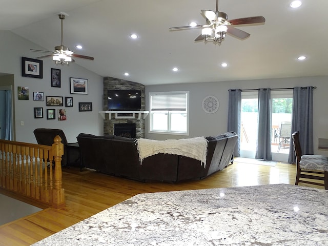 568 Midway Rd, Menomonie, WI 54751 - living area featuring a ceiling fan, light wood finished floors, plenty of natural light, a stone fireplace, and vaulted ceiling