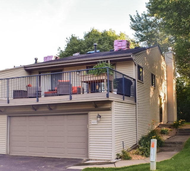 4463 Arden View Ct, Arden Hills, MN 55112 - rear view of property featuring a balcony, an attached garage, a chimney, and driveway