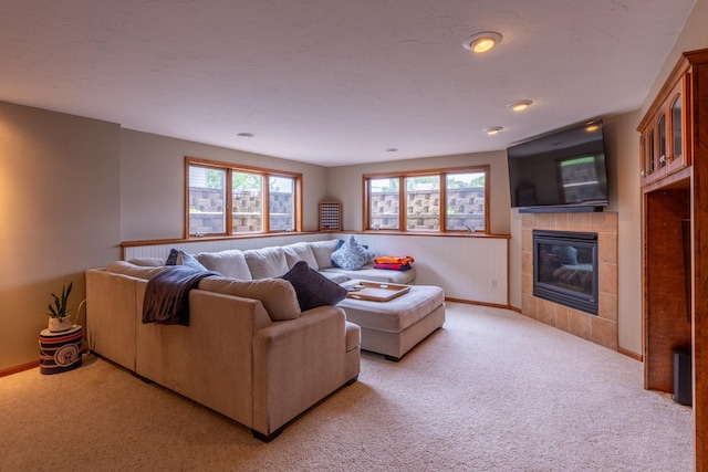 1100 27th St SW, Austin, MN 55912 - living room featuring light carpet, a tiled fireplace, and healthy amount of natural light
