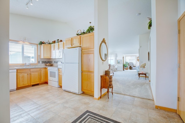 12707 Ivywood St NW, Coon Rapids, MN 55448 - kitchen with white appliances, high vaulted ceiling, rail lighting, light brown cabinets, and light countertops