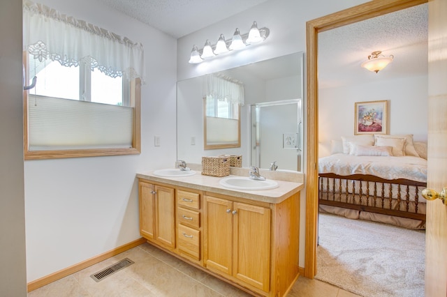 12707 Ivywood St NW, Coon Rapids, MN 55448 - bathroom with double vanity, tile patterned floors, a shower stall, a textured ceiling, and ensuite bathroom