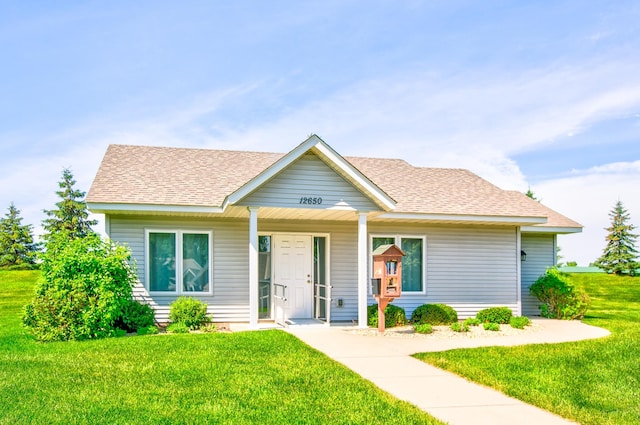 12707 Ivywood St NW, Coon Rapids, MN 55448 - view of front facade with a front yard, a shingled roof, and covered porch