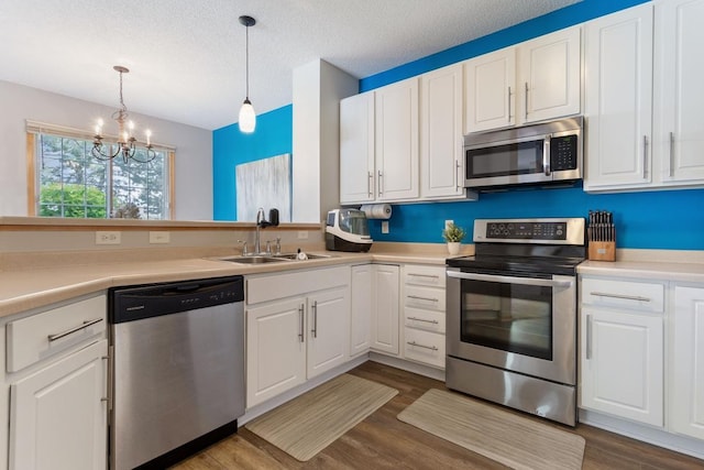 3214 Juniper Cir Unit C, Woodbury, MN 55125 - kitchen with stainless steel appliances, a chandelier, white cabinets, and a textured ceiling