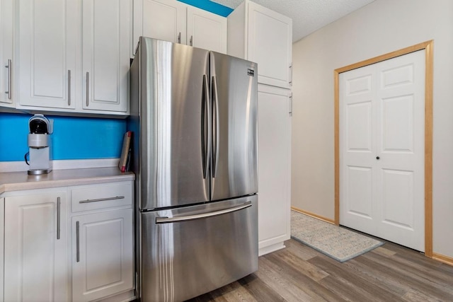 3214 Juniper Cir Unit C, Woodbury, MN 55125 - kitchen featuring freestanding refrigerator, white cabinetry, wood finished floors, and light countertops