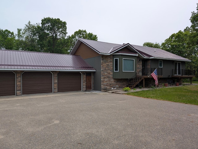 19963 County 18, Henrietta Twp, MN 56470 - view of front of house with stone siding, a metal roof, a garage, and asphalt driveway