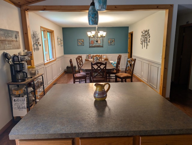 19963 County 18, Henrietta Twp, MN 56470 - dining space with a chandelier, a wainscoted wall, a decorative wall, and dark wood-type flooring