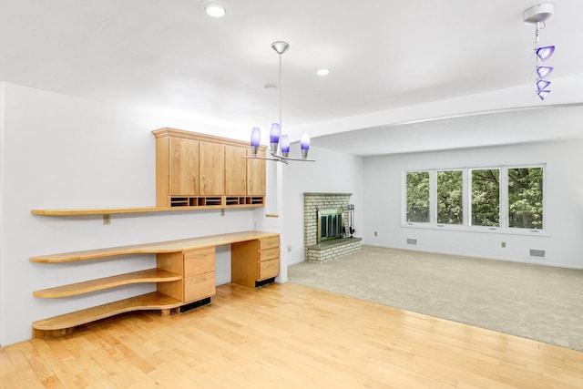 801 Corens Dr, Minnetonka, MN 55305 - unfurnished living room with light wood-style floors, a chandelier, recessed lighting, a brick fireplace, and light colored carpet