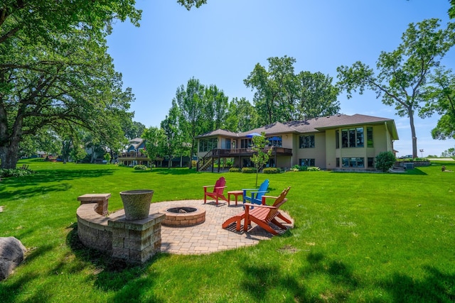870 Andrew Dr NE, Lake Andrew Twp, MN 56273 - view of grassy yard with a fire pit, a wooden deck, stairs, and a patio area