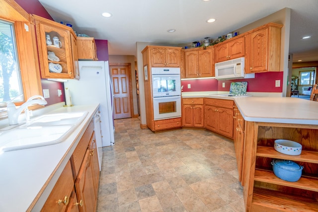 870 Andrew Dr NE, Lake Andrew Twp, MN 56273 - kitchen featuring white appliances, light countertops, recessed lighting, glass insert cabinets, and stone finish flooring