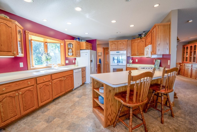 870 Andrew Dr NE, Lake Andrew Twp, MN 56273 - kitchen featuring white appliances, a peninsula, glass insert cabinets, recessed lighting, and light countertops