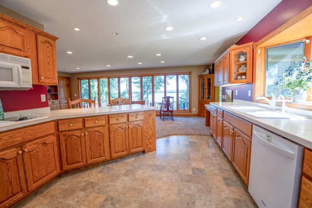 870 Andrew Dr NE, Lake Andrew Twp, MN 56273 - kitchen featuring white appliances, plenty of natural light, recessed lighting, light countertops, and brown cabinets