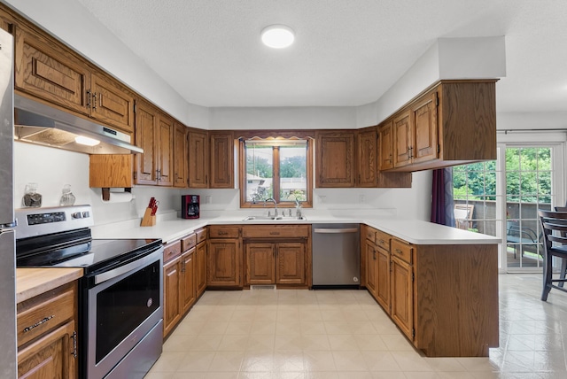 1620 7th St NW, New Brighton, MN 55112 - kitchen with stainless steel appliances, under cabinet range hood, light countertops, and healthy amount of natural light