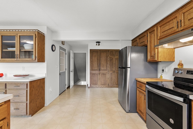 1620 7th St NW, New Brighton, MN 55112 - kitchen featuring appliances with stainless steel finishes, under cabinet range hood, light countertops, and brown cabinetry