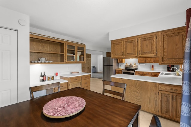 1620 7th St NW, New Brighton, MN 55112 - kitchen featuring appliances with stainless steel finishes, open shelves, light countertops, a peninsula, and brown cabinetry