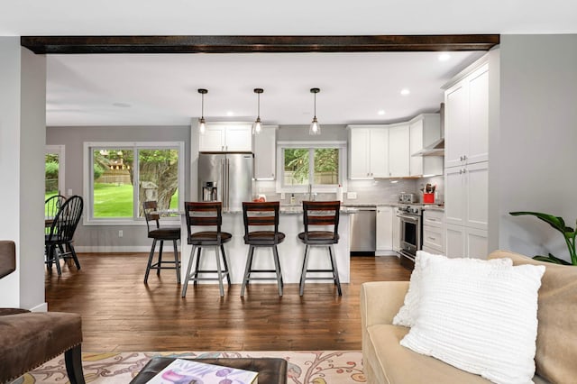 6712 Hillside Ln, Edina, MN 55439 - kitchen featuring stainless steel appliances, wall chimney exhaust hood, recessed lighting, a kitchen breakfast bar, and backsplash