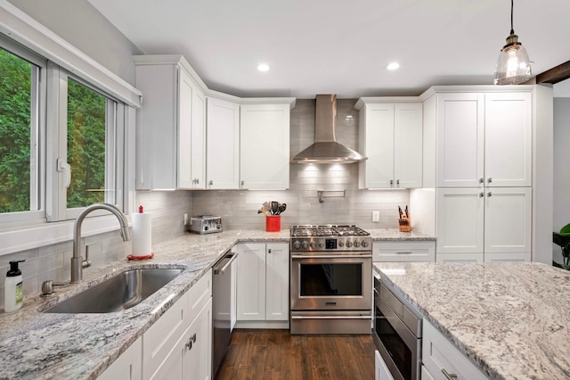 6712 Hillside Ln, Edina, MN 55439 - kitchen featuring appliances with stainless steel finishes, wall chimney range hood, decorative backsplash, white cabinetry, and recessed lighting
