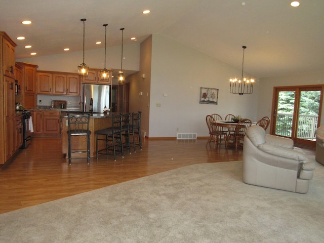 316 8th St NE, Fulda, MN 56131 - living room featuring a chandelier, light wood finished floors, recessed lighting, high vaulted ceiling, and light colored carpet
