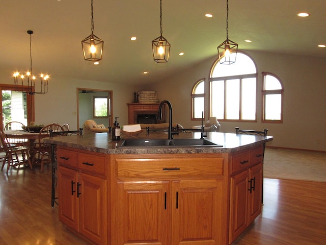 316 8th St NE, Fulda, MN 56131 - kitchen with healthy amount of natural light, lofted ceiling, a breakfast bar area, a chandelier, and wood finished floors