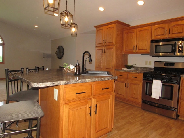 316 8th St NE, Fulda, MN 56131 - kitchen featuring appliances with stainless steel finishes, a kitchen breakfast bar, brown cabinetry, recessed lighting, and light wood-style flooring