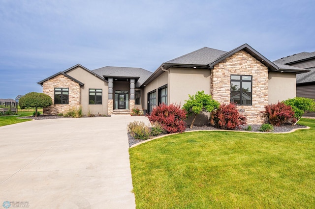 7373 14th St S, Fargo, ND 58104 - view of front of house featuring stone siding, stucco siding, and a front lawn