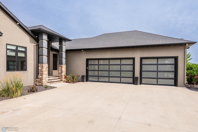 7373 14th St S, Fargo, ND 58104 - view of front of property featuring stucco siding, concrete driveway, a garage, and stone siding