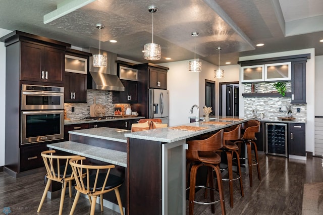 7373 14th St S, Fargo, ND 58104 - kitchen featuring wine cooler, stainless steel appliances, decorative backsplash, dark wood-style flooring, and a spacious island