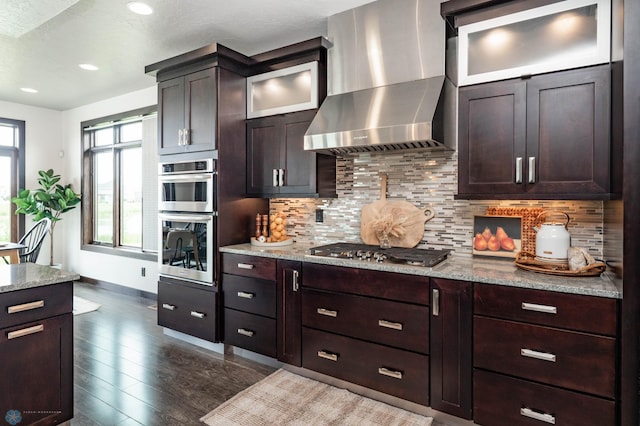 7373 14th St S, Fargo, ND 58104 - kitchen featuring wall chimney exhaust hood, appliances with stainless steel finishes, backsplash, dark wood-type flooring, and recessed lighting
