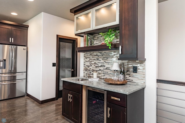7373 14th St S, Fargo, ND 58104 - kitchen featuring stainless steel fridge, beverage cooler, dark brown cabinets, decorative backsplash, and dark wood-type flooring