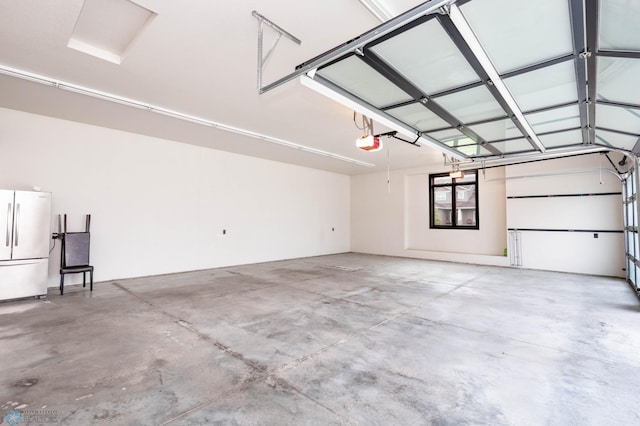7373 14th St S, Fargo, ND 58104 - garage featuring freestanding refrigerator and a garage door opener